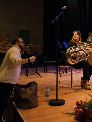 Ausschnit aus der Probe, Professor vor der Bühne, Studierende auf der Bühne mit einer Tuba