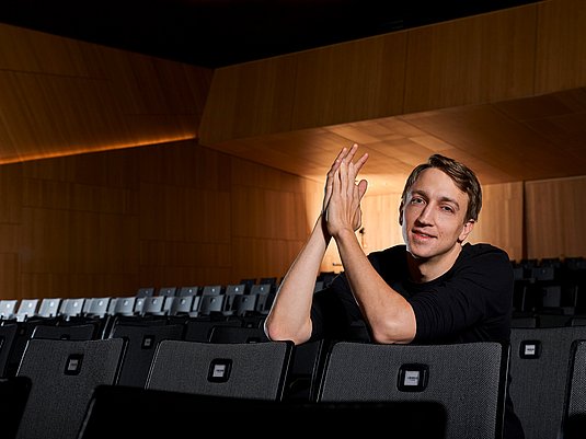 Fabian Müller Person sitzt in einer Stuhlreihe