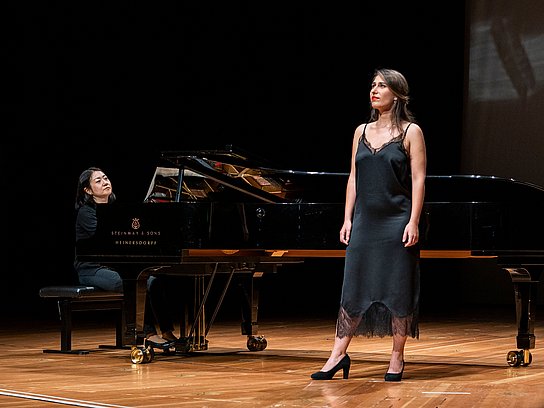 Eine Sängerin steht singend vor dem Flügel an dem eine Pianistin sitzt und spielt